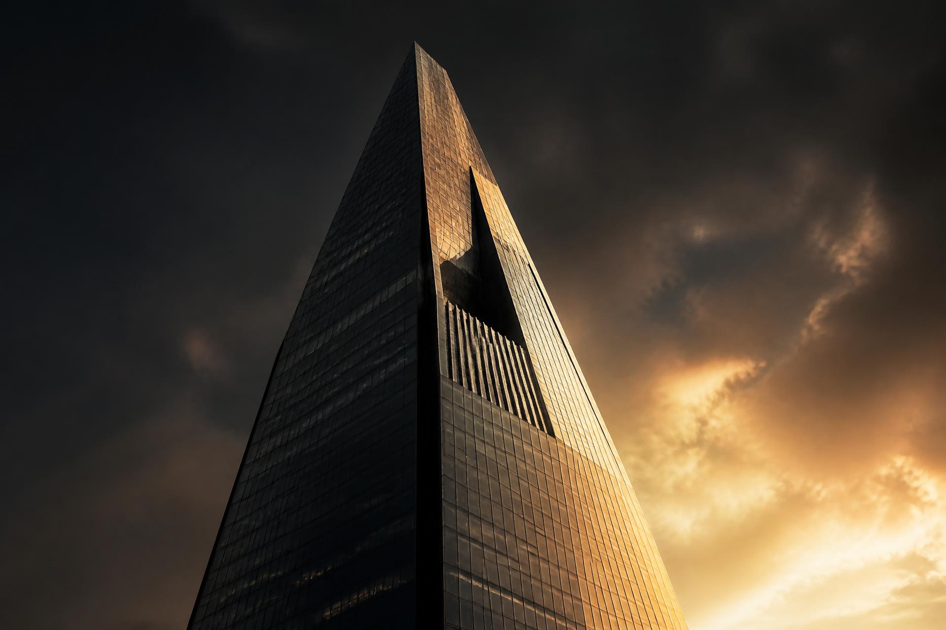 A monolithic luxury tower catching golden dusk light
